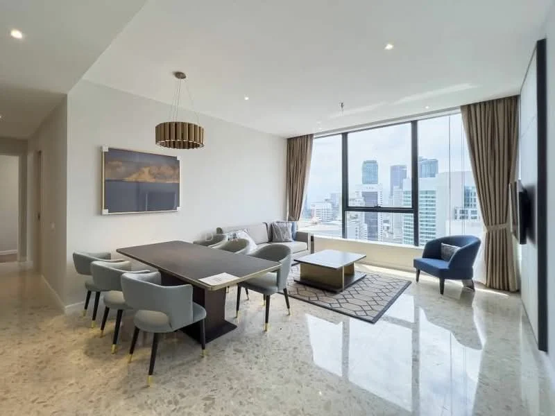Living features: marble flooring, floor-to-ceiling windows, city skyline view, chandelier, recessed downlights, 3-seater fabric sofa in grey, 2-seater fabric sofa, coffee table, 6-seater dining table, upholstered dining chairs, area rug with geometric pattern, decorative wall art, curtains, TV mounted on wall; style: modern; view: city.