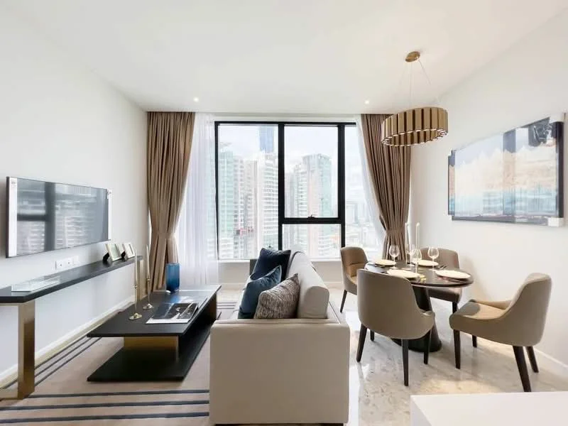 Living features: floor-to-ceiling windows, city skyline view, light grey walls, marble flooring, chandelier, sofa in light beige, black coffee table, TV console, wall-mounted TV, dining table for four, upholstered dining chairs, decorative wall art, curtains, area rug with stripes; style: modern; view: city.