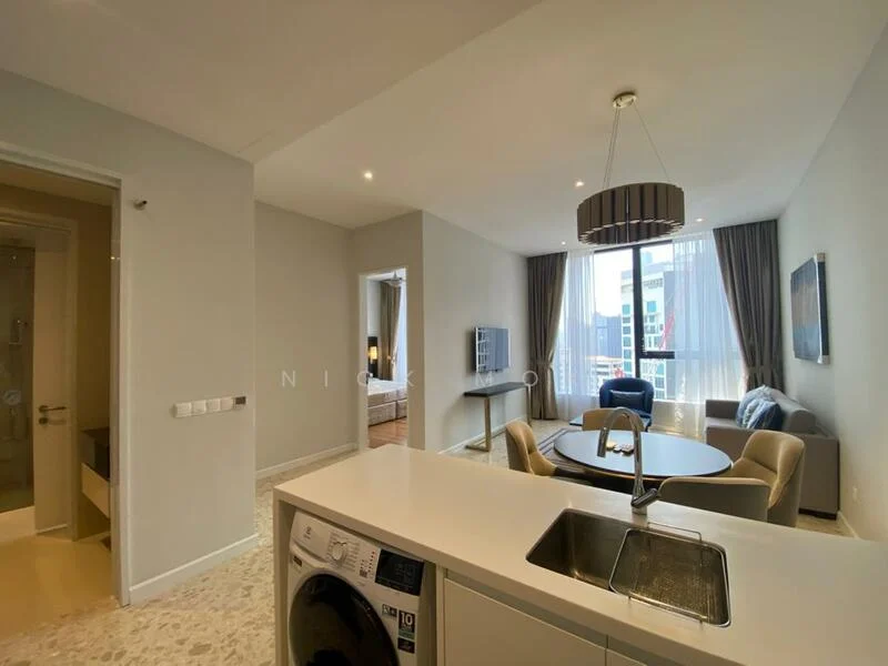 Living features: light grey painted walls, large floor-to-ceiling windows, curtains, sofa in blue fabric, round dining table, upholstered dining chairs, TV console, wall-mounted TV, area rug, recessed downlights, ceiling light fixture; style: modern; view: city. Kitchen features: white cabinetry, stainless-steel sink, single-bowl stainless-steel sink, built-in washing machine, countertop, recessed downlights; style: modern. Room features: doorway leading to bedroom, bathroom visible in background.