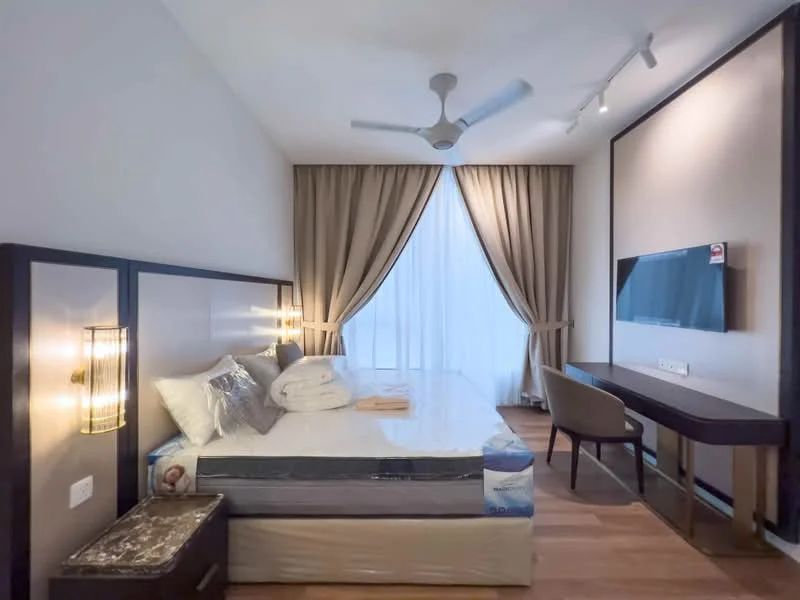Bedroom features: king-size bed, upholstered headboard, bedding with pillows, wooden flooring, floor-to-ceiling window, sheer curtains, wall-mounted TV, desk with chair, 2 bedside lamps, ceiling fan with light, decorative wall lighting; style: modern.