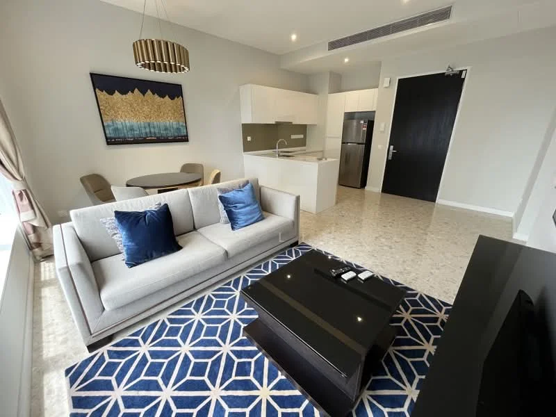Living features: 3-seater fabric sofa in light grey, blue decorative cushions, black coffee table, area rug with geometric pattern in blue and white, wall-mounted TV, TV console, pendant light fixture, large window with sheer curtains, marble flooring, neutral painted walls; style: modern. Kitchen features: white cabinetry, stainless-steel fridge, built-in oven, ceramic cooktop, kitchen island with sink, countertop with backsplash, open shelving; style: modern. Dining features: round dining table, 4 upholstered dining chairs; style: modern.