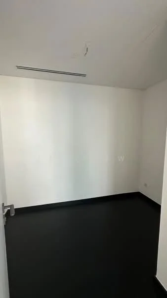 Room features: white painted walls, black flooring, ceiling with air conditioning vent, door with metallic handle.