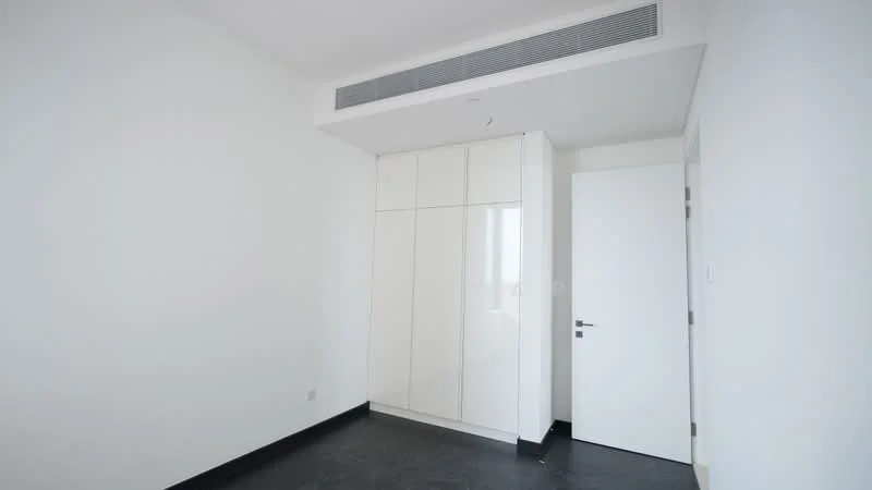 Room features: white painted walls, black flooring, built-in white cabinetry, single white door, air conditioning vent, minimalist design; style: modern.