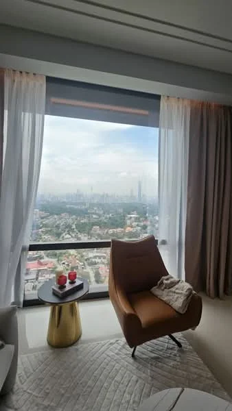 Living features: floor-to-ceiling windows, city view, curtains, armchair in brown, small round side table, decorative items on table, area rug, neutral wall color; style: modern; view: city.