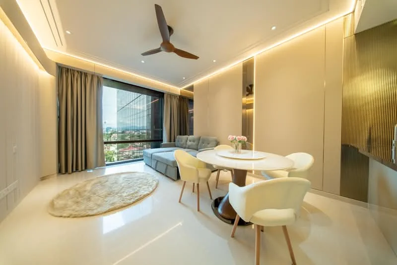 Living features: 5-blade ceiling fan with light, floor-to-ceiling windows, grey fabric sectional sofa, round dining table, upholstered dining chairs, area rug with circular shape, recessed downlights, cream painted walls, marble flooring, curtains, decorative vase with flowers; style: modern; view: city.