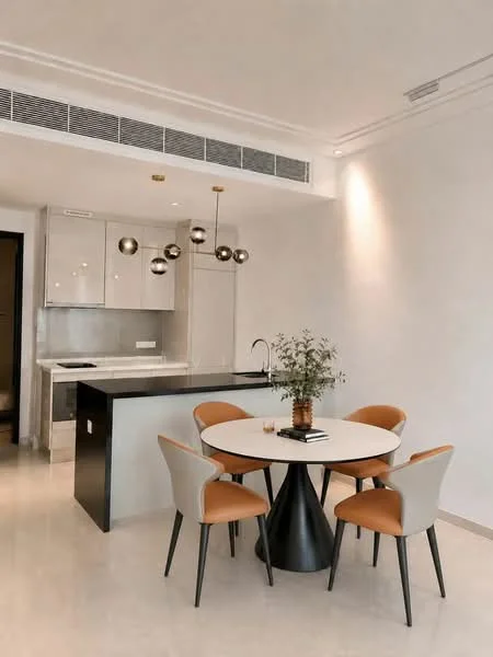 Dining features: round dining table, 4 upholstered dining chairs in grey and orange, decorative vase with greenery on table, pendant light fixture with spherical bulbs, white walls, marble countertop, kitchen island, recessed downlights, floor-to-ceiling windows, open layout to kitchen; style: modern. Kitchen features: stainless-steel sink, chrome pull-down faucet, built-in oven, freestanding range oven, kitchen cabinetry, grey cabinetry, black countertop, recessed lighting; style: modern.