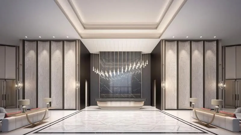 Room features: marble flooring, high ceiling with tray design, chandelier lighting, feature wall with dark marble, light wood paneling, recessed downlights, two decorative side tables with lamps, symmetrical seating arrangement, geometric pattern on flooring, elegant wall decor; style: luxury.