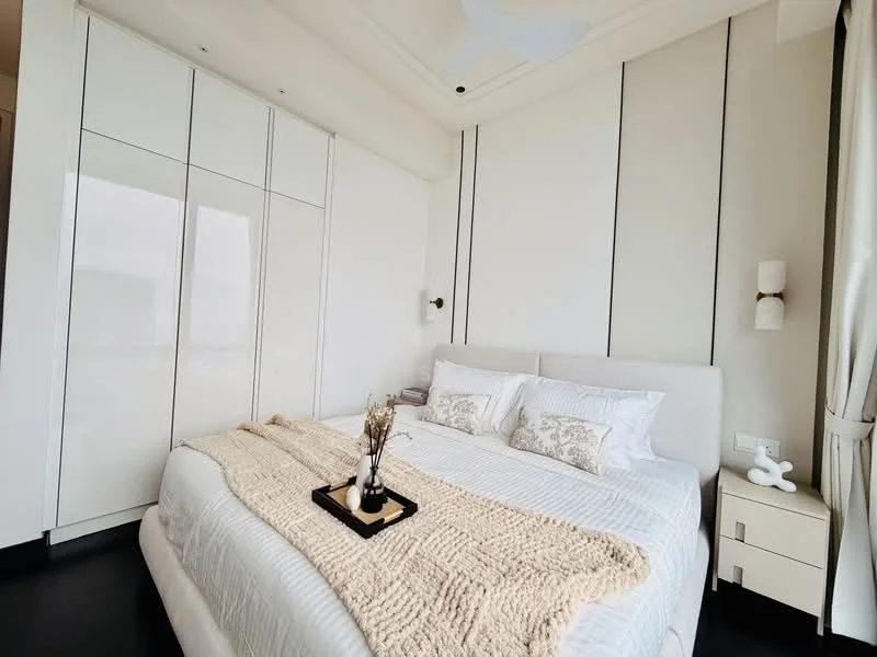 Bedroom features: king-size bed with upholstered headboard, white bedding with decorative pillows, built-in wardrobe with white finish, nightstand with lamp, decorative tray on bed, textured throw blanket, wall-mounted sconces, dark wood flooring, ceiling fan, recessed ceiling with crown moulding; style: modern.