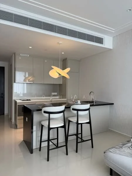 Kitchen features: white cabinetry, black countertop, stainless-steel sink, chrome pull-down faucet, built-in oven, freestanding range oven, recessed downlights, pendant light, bar seating with two stools, open layout, tile flooring, wall-mounted air conditioning unit; style: modern.