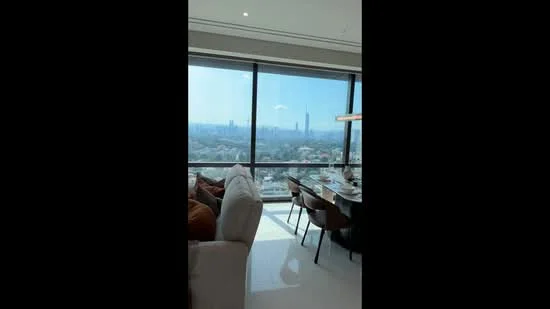 Living features: floor-to-ceiling windows, city skyline view, light-colored sofa, wooden dining table, upholstered dining chairs, recessed downlights, neutral wall color, polished tile flooring; style: modern; view: city.
