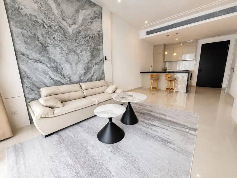 Living features: cream leather sofa, 2 round coffee tables with marble tops, area rug with grey pattern, marble accent wall, polished tile flooring, recessed downlights, kitchen island with bar stools, open layout to kitchen, floor-to-ceiling windows, neutral wall color; style: modern.