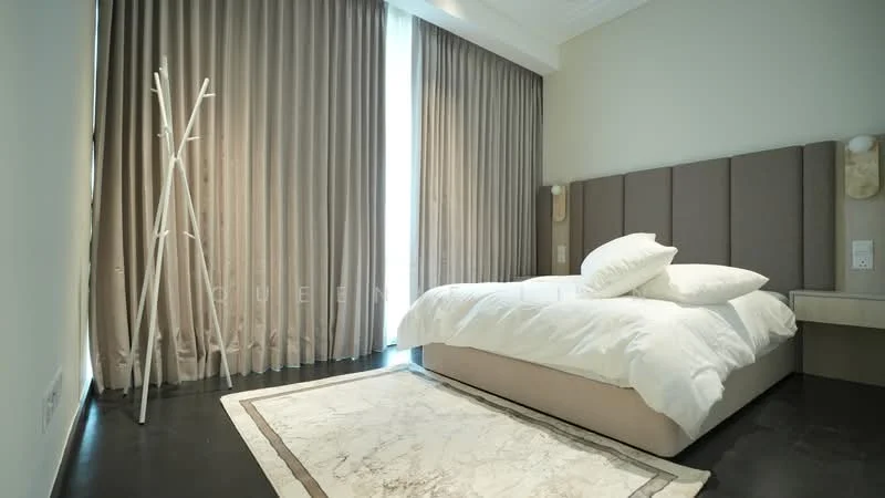 Bedroom features: king-size bed with white bedding, upholstered headboard in beige, floor-to-ceiling windows, sheer curtains, dark wood flooring, decorative area rug with marble pattern, bedside table, wall-mounted light fixtures, minimalist decor, clothes rack, neutral wall color; style: modern.
