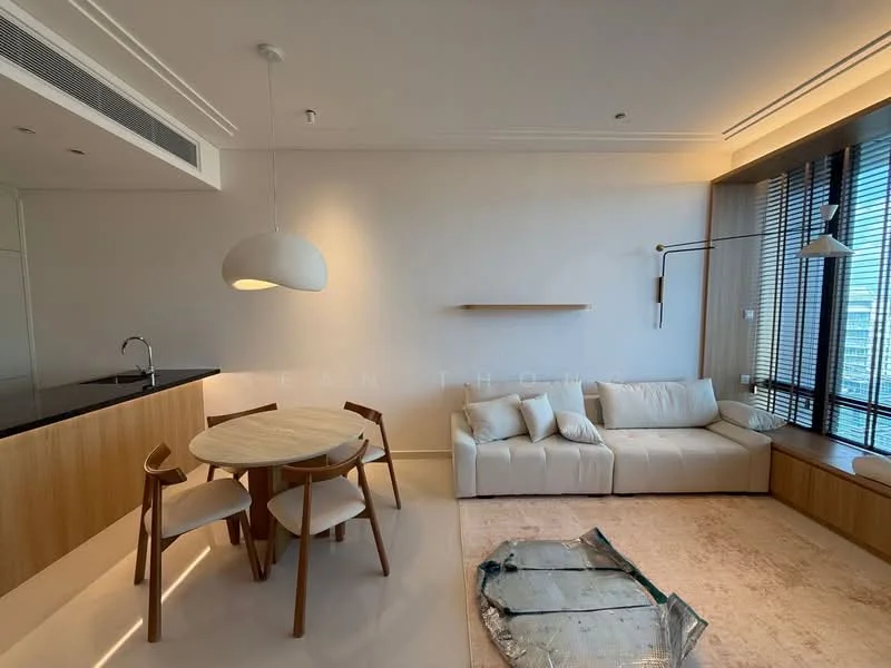 Living features: white painted walls, light wood paneling, large windows with blinds, sofa in cream fabric, round dining table in light wood, 3 dining chairs in light wood, pendant light fixture, area rug in neutral tones, built-in shelf, kitchen counter with dark surface; style: modern; view: city.