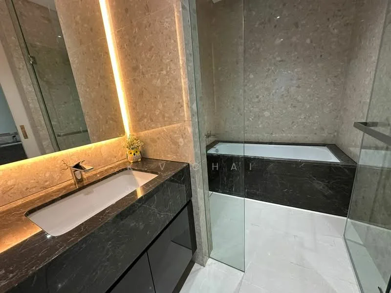 Bathroom features: single-sink vanity with black cabinet, white rectangular sink, chrome basin mixer faucet, mirror with backlighting, bathtub with glass enclosure, grey marble wall cladding, black marble flooring, recessed lighting; style: modern.
