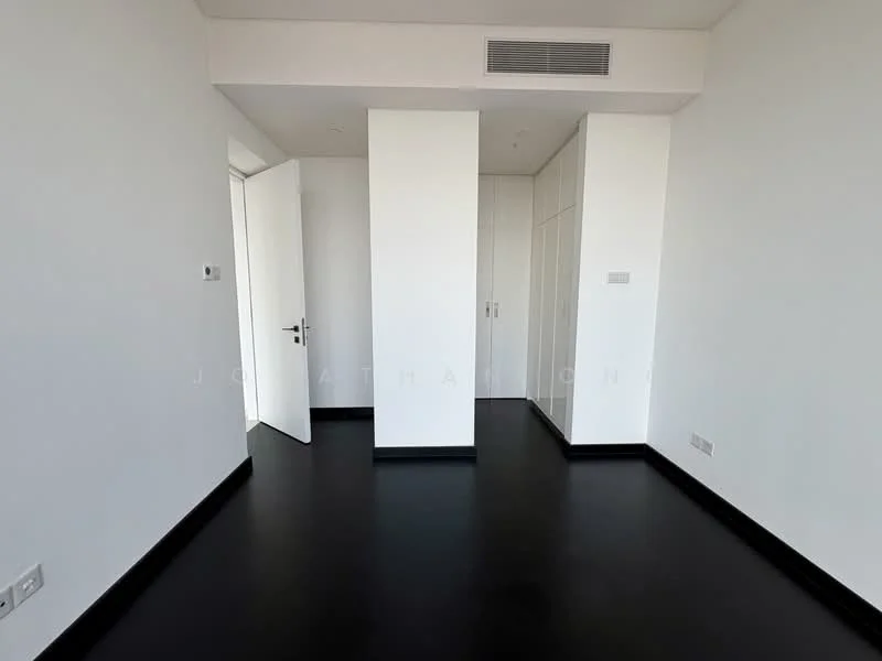 Room features: white painted walls, black vinyl flooring, built-in wardrobe with sliding doors, door leading to another room, air conditioning vent, light switch, window with no visible treatment; style: modern.