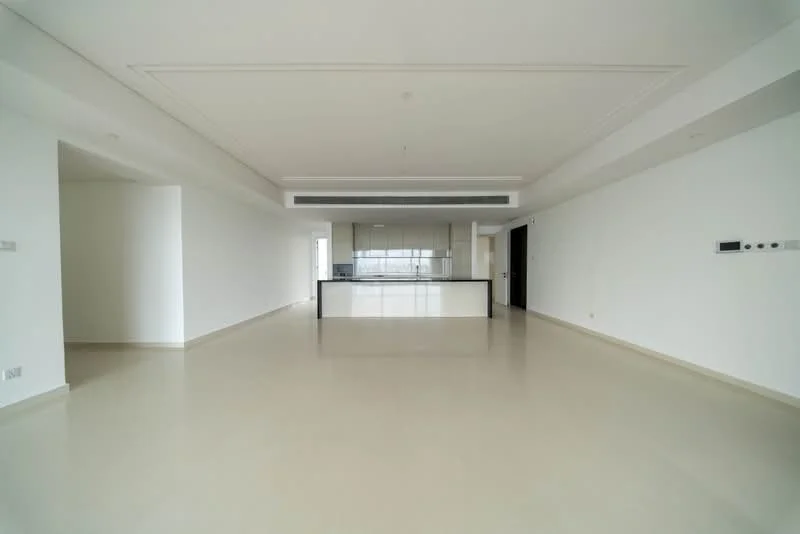 Living features: white painted walls, smooth plaster ceiling with recessed lighting, large open space, light-colored flooring, floor-to-ceiling windows, kitchen island with bar seating, open layout connecting to kitchen, minimalist design; style: modern; view: city.