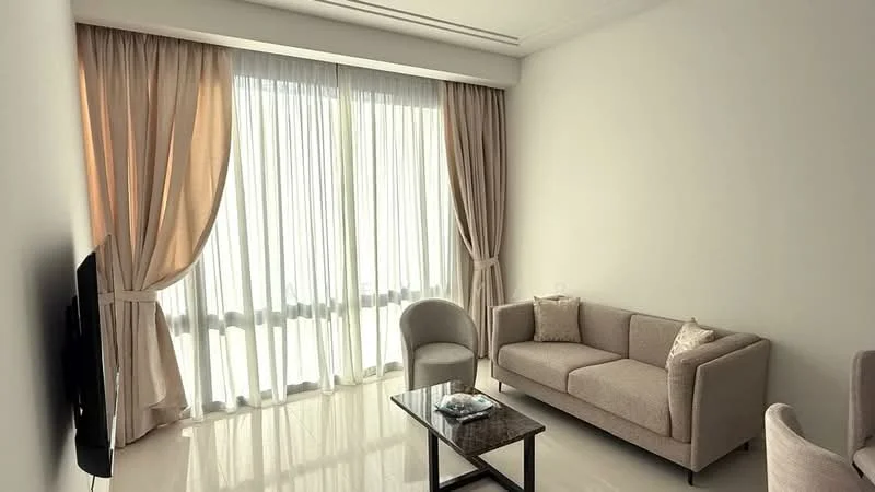 Living features: light beige fabric sofa, glass coffee table, floor-to-ceiling windows, sheer curtains, cream walls, glossy tile flooring, decorative cushion, wall-mounted TV; style: modern.