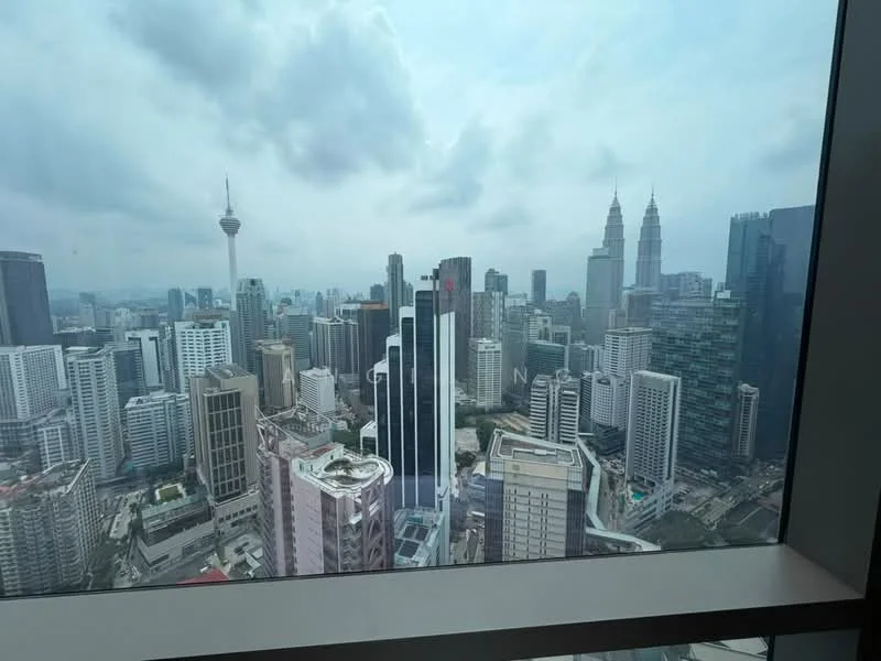 Exterior type: high-rise condominium; features: city skyline view, glass curtain wall, surrounded by urban landscape, visible telecommunications tower, prominent twin towers, varied building heights, modern architectural designs; style: modern.
