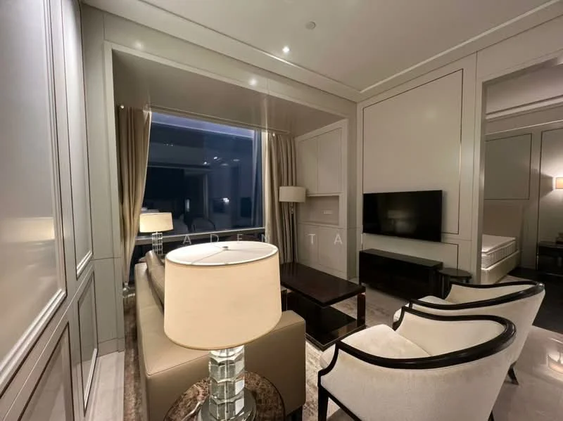Living features: cream painted walls, marble flooring, floor-to-ceiling windows, sheer curtains, wall-mounted TV, 2-seater sofa in beige, coffee table, 2 accent chairs, decorative lamp, recessed downlights; style: modern; view: city.