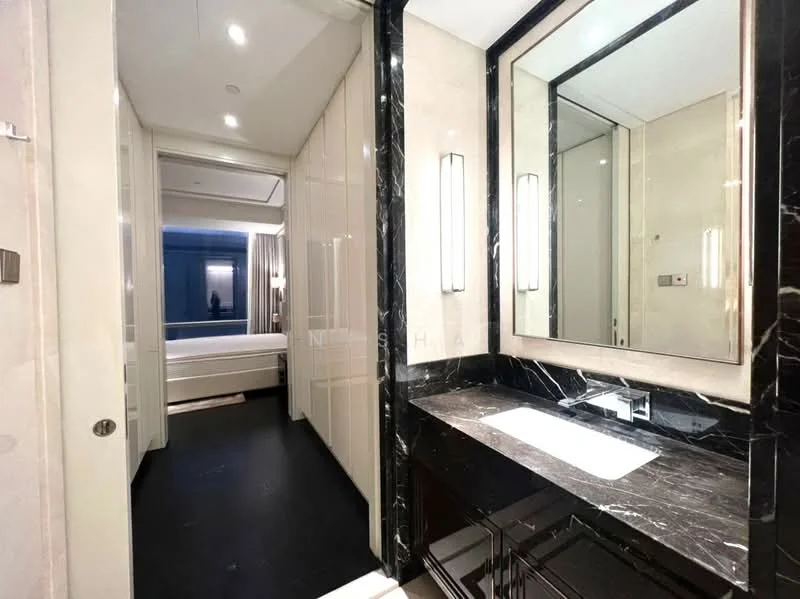 Bathroom features: black marble countertop, double-sink vanity with black cabinetry, framed mirror, wall-mounted lighting fixtures, white walls, dark flooring, sliding door to adjacent room, recessed lighting; style: modern.