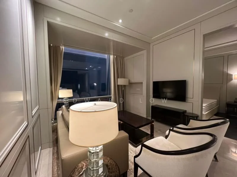 Living features: cream painted walls, grey accent wall, marble flooring, floor-to-ceiling windows, sheer curtains, wall-mounted TV, coffee table, 2-seater fabric sofa in beige, 2 armchairs with wooden frames, table lamp, decorative mirror, recessed downlights; style: modern; view: city.