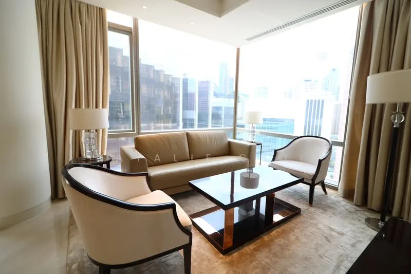 Living features: beige leather sofa, 2 upholstered armchairs in cream, glass coffee table with black base, area rug with neutral tones, floor-to-ceiling windows, sheer curtains, city skyline view, recessed downlights, cream painted walls, marble flooring; style: modern; view: city.