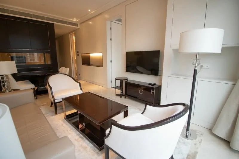 Living features: light grey wall, cream painted walls, recessed downlights, wall-mounted TV, dark wood coffee table, 2 white upholstered armchairs, beige sofa, light-colored area rug, dark wood console table, floor-to-ceiling windows, curtains, decorative lamp; style: modern; view: city.