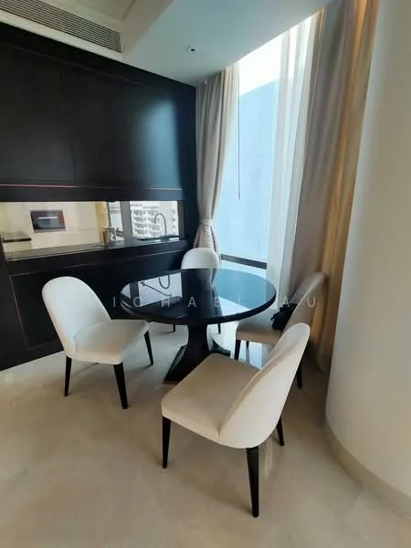 Dining features: round dining table, 4 upholstered dining chairs, black table with circular top, cream upholstery on chairs, floor-to-ceiling windows, curtains, light-colored flooring, kitchenette area visible in background; style: modern; view: city.