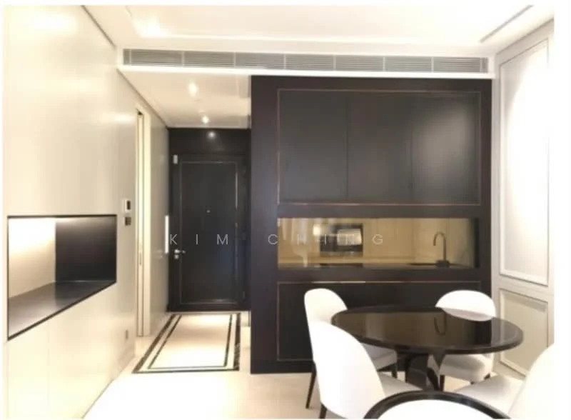 Dining features: round dining table, white upholstered dining chairs, black cabinetry, built-in kitchen area, recessed lighting, white painted walls, dark accent wall, floor-to-ceiling door, black countertop, kitchen sink, microwave, oven; style: modern.