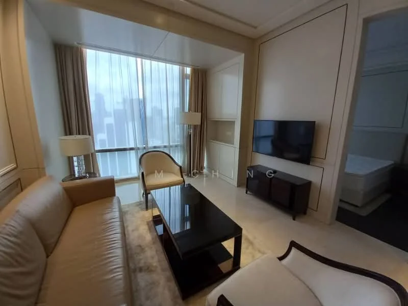 Living features: cream painted walls, marble flooring, floor-to-ceiling windows, sheer curtains, 3-seater beige leather sofa, 2-seater cream armchair, black coffee table, wall-mounted flat-screen TV, wooden TV console, decorative wall paneling, area rug with neutral tones; style: modern; view: city.