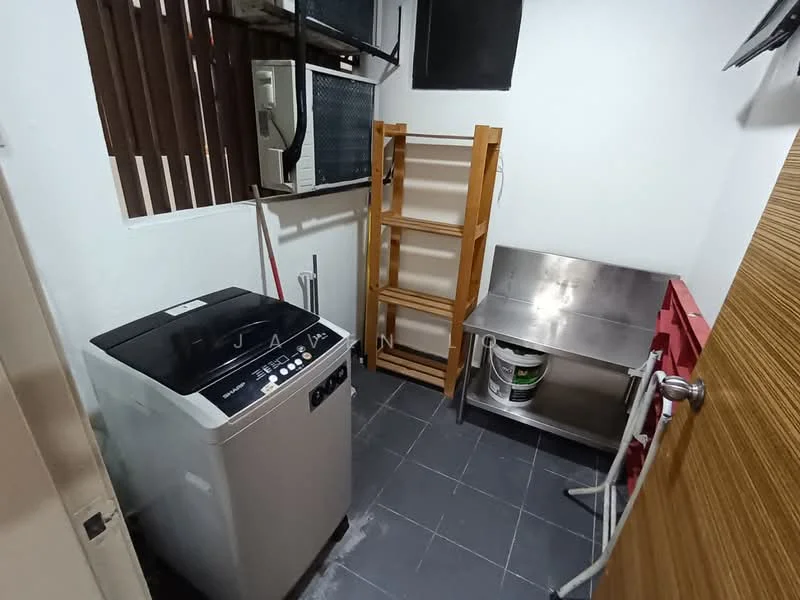 Laundry features: top-load washing machine, metal utility table, wooden shelving unit, grey tiled flooring, white painted walls, window with blinds, air conditioning unit, bucket, cleaning supplies.