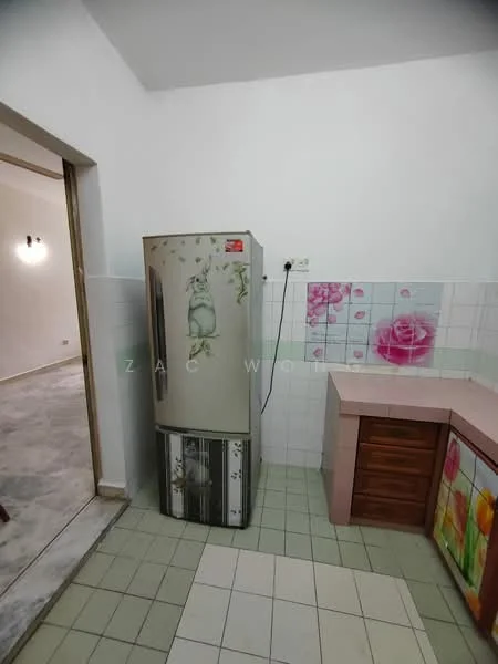 Kitchen features: fridge, pink laminate countertop, wood cabinetry, white tiled backsplash with floral pattern, green floor tiles, white painted walls, wall-mounted electrical outlet.