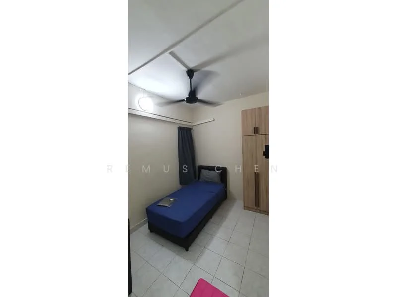 Bedroom features: single bed with blue bedding, wooden wardrobe, ceiling fan, tiled flooring, cream painted walls, window with sheer curtains, nightstand, book on bed.