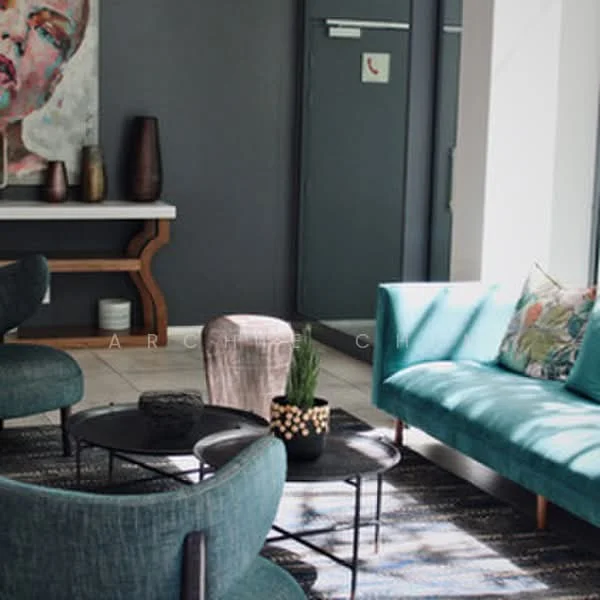 Living features: teal fabric sofa, 2 round black coffee tables, area rug with geometric pattern, wooden console table, decorative vase on console table, framed artwork on wall, floor-to-ceiling windows, wall-mounted intercom, light-colored tiled flooring; style: modern.
