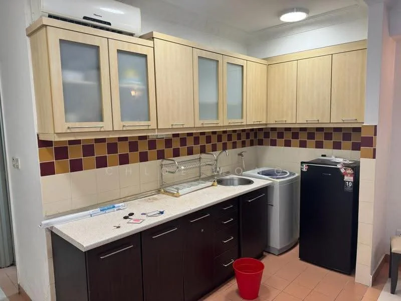 Kitchen features: laminate cabinetry in light wood, dark wood lower cabinets, white countertop, single-bowl stainless-steel sink, chrome pull-down faucet, built-in washing machine, stainless-steel fridge, tile backsplash with maroon and beige pattern, recessed ceiling lights, wall-mounted split AC unit, orange plastic bucket on floor, ceramic tile flooring in light peach; style: modern.