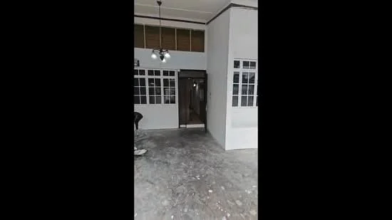 Room features: white painted walls, concrete flooring, ceiling with recessed lighting, multiple windows with grid design, main entrance door, open layout, high ceiling; style: modern.