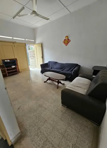 Living features: 2-seater fabric sofa in grey, 3-seater fabric sofa in navy blue, round coffee table with wooden legs, light-colored tiled flooring, white painted walls, ceiling fan, built-in wardrobe with yellow doors, window with metal grille, decorative wall hanging.