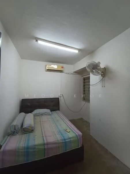 Bedroom features: single bed with dark wood headboard, plaid bedspread in pastel colors, 1 wall-mounted split AC, ceiling fan, white painted walls, concrete flooring, window with blinds, light fixture with fluorescent lights.