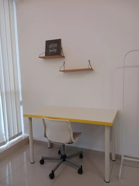 Study features: white desk with yellow trim, rolling office chair with wheels, two wooden shelves mounted on the wall, white walls, glossy tile flooring, vertical blinds on window; style: modern.