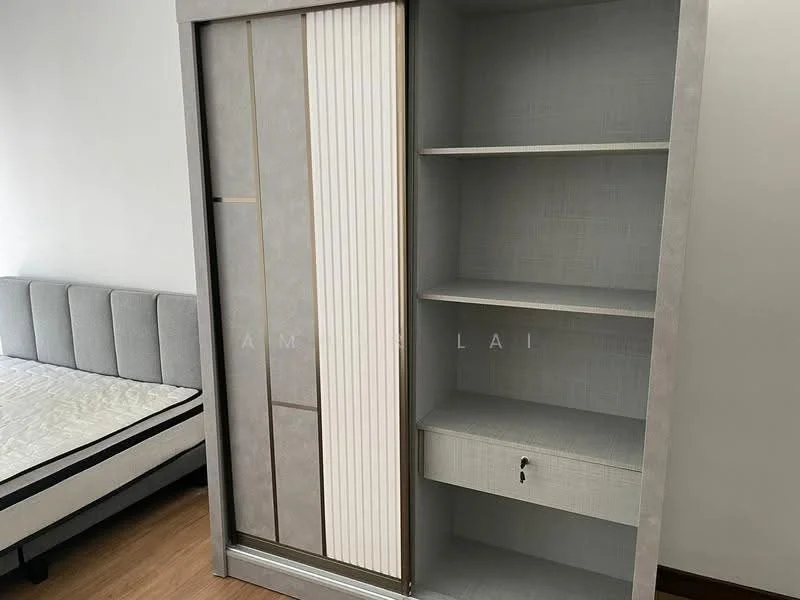Room features: grey upholstered bed frame, mattress on bed frame, built-in wardrobe with sliding doors, shelves inside wardrobe, drawer in wardrobe, wooden flooring, neutral wall color; style: modern.
