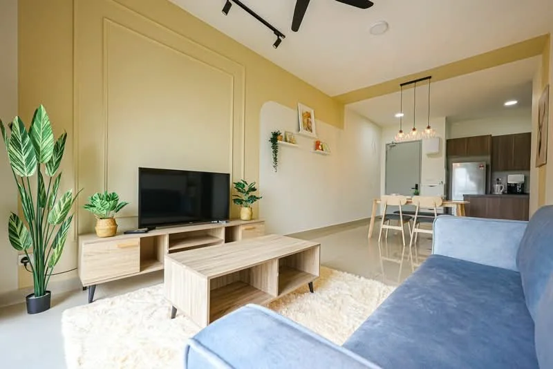 Living features: 3-seater fabric sofa in blue, wooden coffee table, TV console, wall-mounted TV, area rug with fluffy texture, potted plants, decorative wall shelf, recessed ceiling lights, ceiling fan, cream painted walls, glossy tile flooring; style: modern. Dining features: 4-seater dining table, wooden dining chairs, open kitchen view, kitchen appliances visible; style: modern.