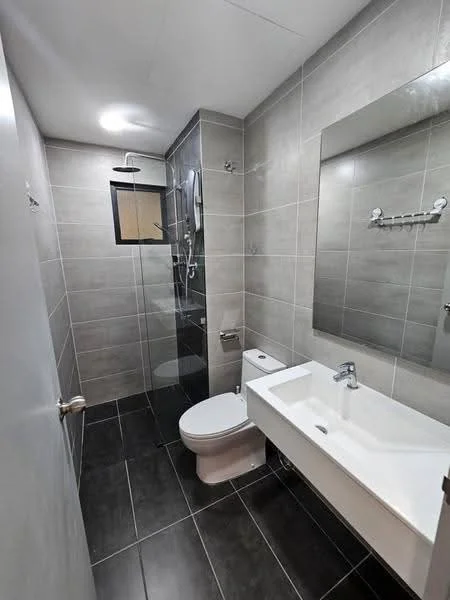 Bathroom features: grey tiled walls, black tiled flooring, single-sink vanity with white cabinet, chrome basin mixer faucet, framed mirror, walk-in shower with glass enclosure, rain shower head, handheld shower, one-piece toilet, wall-mounted towel rack, shower niche, recessed ceiling lights; style: modern.