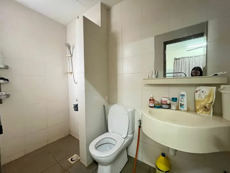 Bathroom features: white tiled walls, grey tiled flooring, walk-in shower with glass partition, chrome shower head, toilet with flush, sink with wall-mounted shelf, mirror above sink, curtain for privacy, bottle storage on shelf.