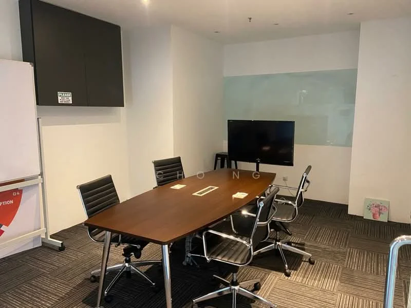 Room features: rectangular wooden conference table, six black leather office chairs, wall-mounted flat-screen TV, whiteboard on wheels, glass partition wall, grey carpet flooring, recessed ceiling lights, wall-mounted storage cabinet; style: modern.