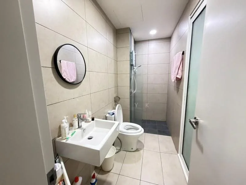 Bathroom features: light grey tiled walls, light grey tiled flooring, round mirror, wall-mounted sink, white toilet, glass shower enclosure, shower head, two pink towels hanging, white door, recessed lighting; style: modern.