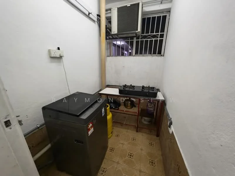 Kitchen features: white painted walls, tile flooring, 2-burner gas hob, stainless-steel sink, washing machine, wooden countertop, window with security bars, wall-mounted air conditioning unit.