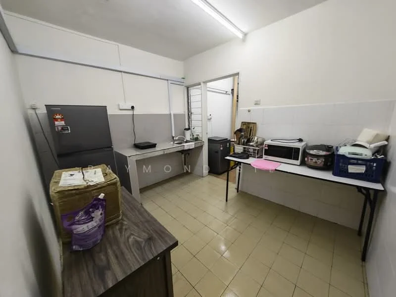 Kitchen features: grey laminate countertops, white tiled backsplash, stainless-steel fridge, built-in microwave, freestanding range oven, kettle, toaster, wooden cabinetry, tile flooring, overhead fluorescent lighting, open shelving, plastic storage bins.
