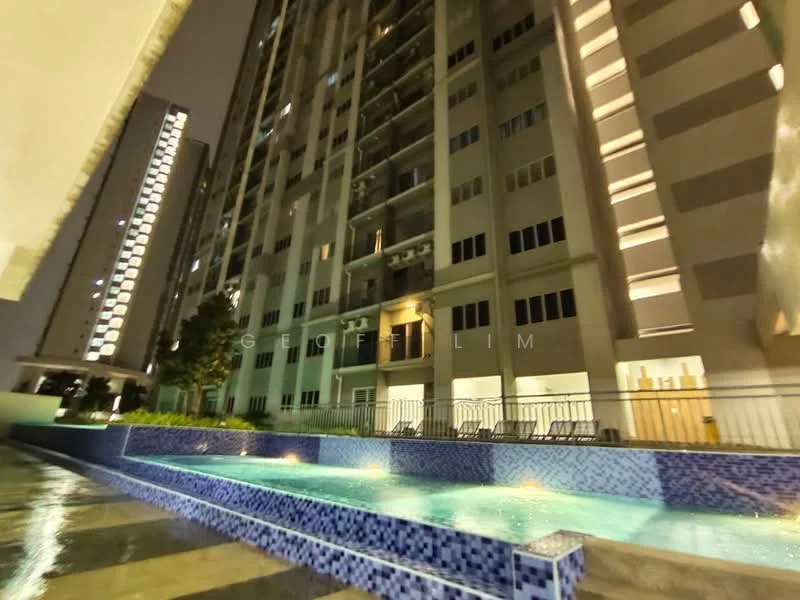 Exterior type: high-rise condominium; features: swimming pool with tiled edge, pool deck with loungers, illuminated building facade, multiple storeys visible, balconies on upper floors, landscaped area with trees, glass railing around pool, night lighting on building, modern architectural design; style: modern.