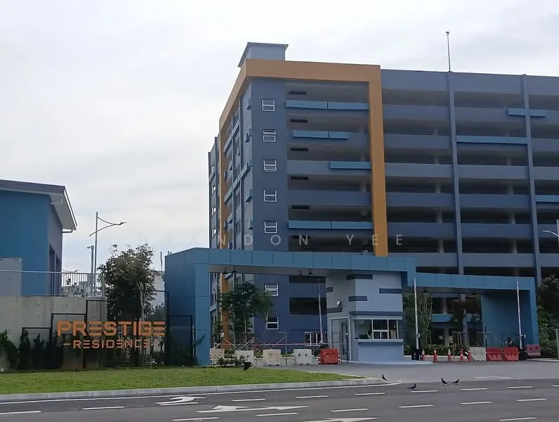 Exterior type: mid-rise condominium; features: blue painted facade, orange accent panels, multiple floors, entrance with security gate, landscaped area with plants, parking area visible, signage with 'Prestige Residences', surrounding road, street lighting, windows with horizontal slats; style: modern.