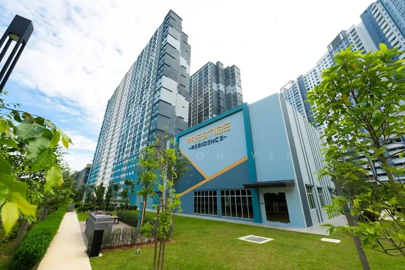 Exterior type: high-rise condominium; features: blue and grey painted facade, glass curtain wall, manicured lawn, landscaped garden with trees, walkway leading to the building, signage with 'Prestige Residence', multiple storeys visible, surrounded by greenery; style: modern.